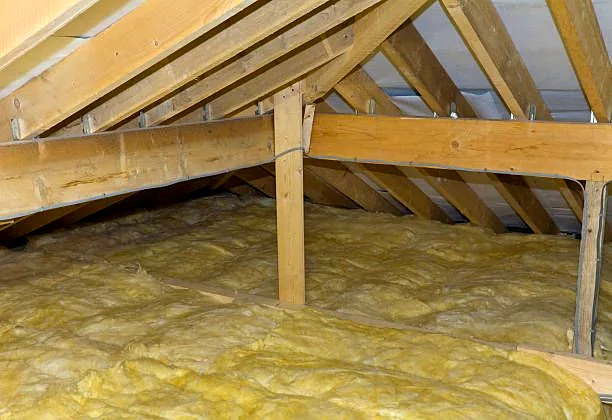 Charpente traditionnelle en chêne au-dessus d'un comble isolé en laine de verre