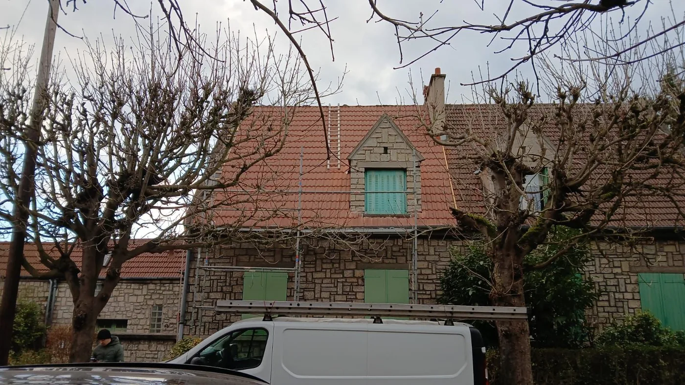 Maison de village et sa couverture en tuiles, camionnette devant